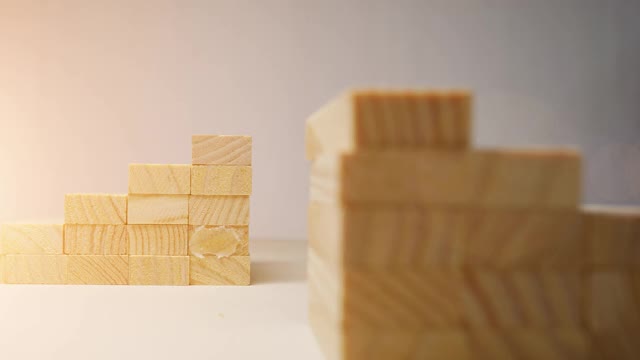 木块堆叠在一起。用于多米诺游戏。与阳光的动画。卡车从右向左射击。堆叠成楼梯的形状。焦点在后面。视频下载