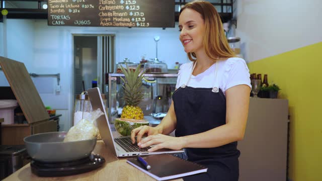 在餐厅工作的女服务员在笔记本电脑上输入他们要求的订单视频下载