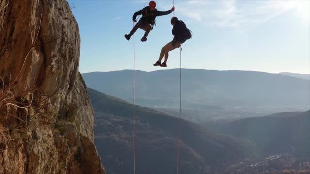 两个无所畏惧的攀岩者挂在一根绳子上视频下载