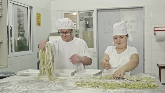 西班牙意大利面工人把撒了面粉的意大利面放在盒子里的实时视频视频素材