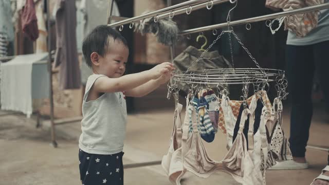 小男孩帮妈妈晾洗好的衣服视频下载