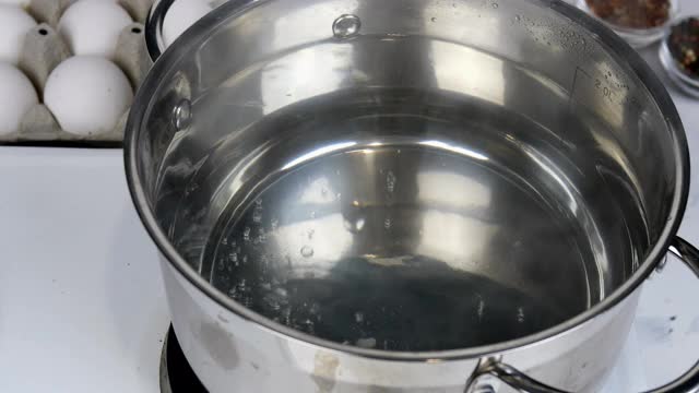 煮水煮蛋的食谱。生鸡蛋放入平底锅的沸水中。视频素材
