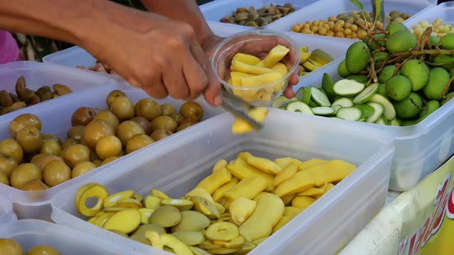 手拿腌渍水果给顾客，泰国街头小吃视频下载