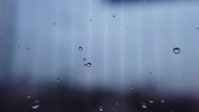 巨大的雨滴落在窗户玻璃上视频素材