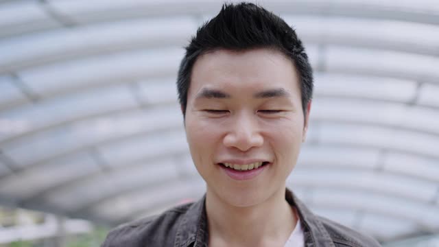 亚洲男人脸特写在说话或介绍一个快乐的微笑。良好的友谊。面部皱纹和牙齿健康。积极思考的概念视频素材