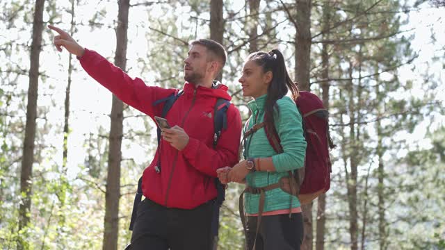年轻的徒步旅行夫妇试图在互联网和全球定位系统的帮助下确定方向，在他们的徒步旅行中找到正确的方向视频下载