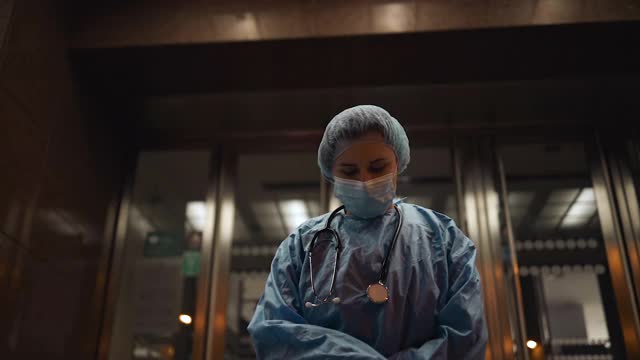 悲伤的女护士或医生在医院附近上夜班时情绪低落视频素材