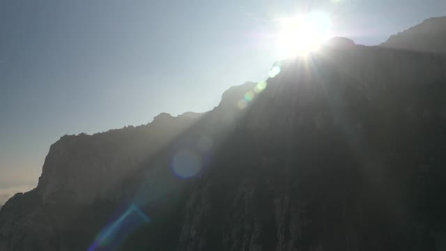 慢镜头的阳光流越过美丽的蒙特塞拉特山在巴塞罗那，西班牙。高质量4k镜头视频下载