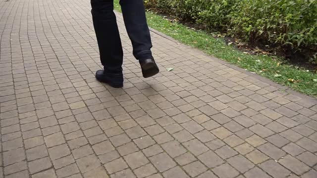 一个人走在人行道上的腿的特写视频素材