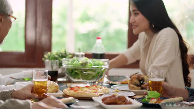 4K超高清手持:快乐的亚洲多代家庭干杯和一起用餐。视频下载