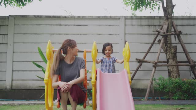 年轻的亚洲母亲和她的女儿在公园玩视频下载