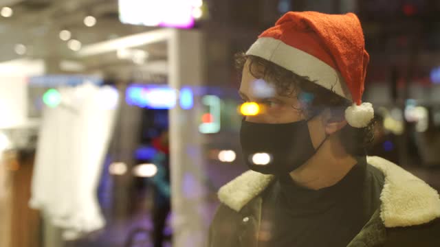 一个戴着防毒面具的男人透过商店橱窗看圣诞礼物的概念视频下载