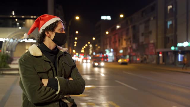 一名男子在头发上戴着圣诞老人帽。在一场流行病中庆祝新年。视频下载