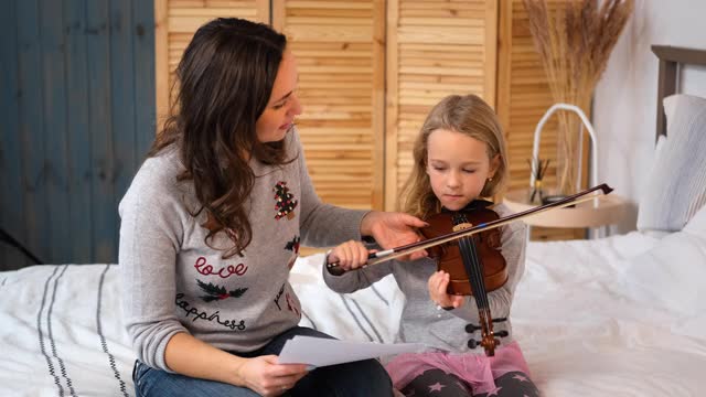 妈妈在家教小女孩拉小提琴视频素材