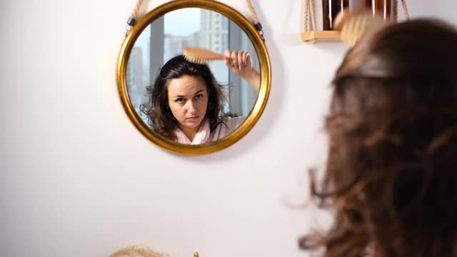 在浴缸镜子前梳头的女人视频素材