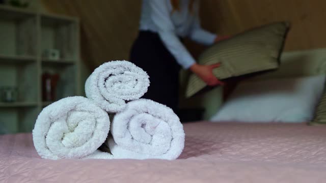 房间服务。在旅馆房间里铺床的女人。视频下载
