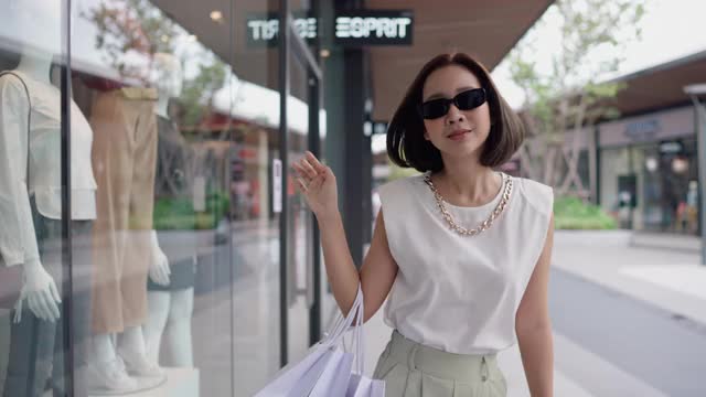 自信的女人微笑着走在购物袋视频素材
