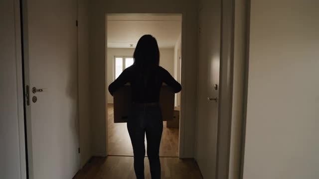 一个女人提着一个箱子进了她的新公寓视频下载