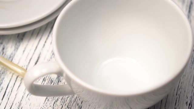 将烤好的阿拉比卡咖啡豆倒进桌子上的一只白色杯子里视频素材