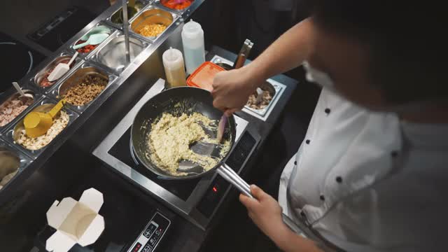 一名男性厨师在冠状病毒大流行期间烹饪的高视角视频下载