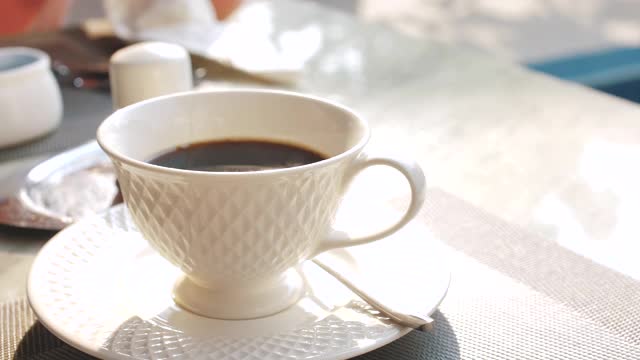 牛奶从牛奶壶流入一杯黑咖啡视频素材
