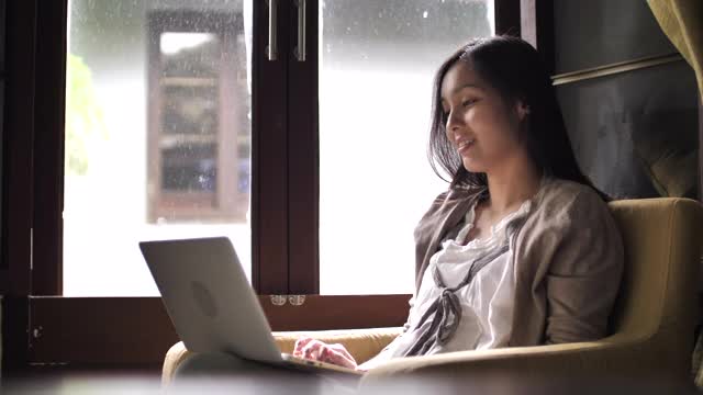 亚洲女人在家里用笔记本电脑视频素材