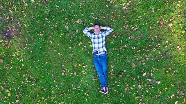 躺在草地上的男人的鸟瞰图视频下载