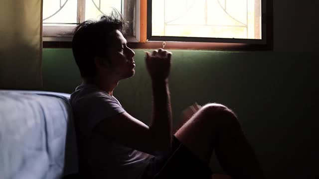 年轻的亚洲男人在黑暗的房间里沮丧、焦虑和压力。视频素材