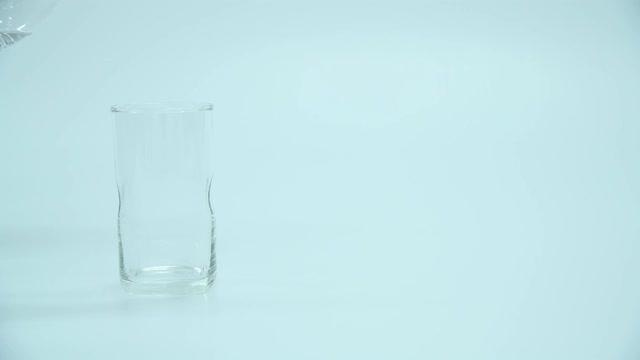 一瓶水倒进一个玻璃杯里视频素材