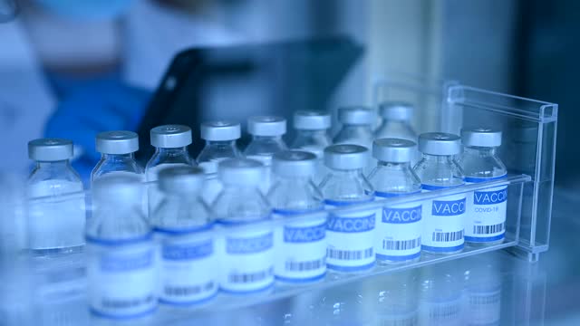 女性研究人员在冰箱中检查病毒疫苗。视频素材