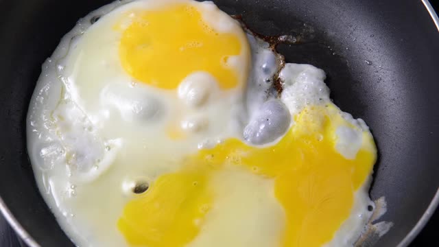 在煎锅里煎鸡蛋是早餐的好方法。视频素材