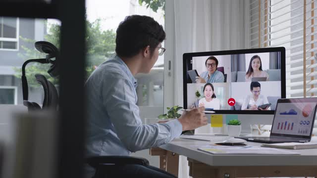 商人在视频会议中谈论销售报告。亚洲团队使用笔记本电脑和平板电脑进行在线视频会议。在家工作，远程工作和在家自我隔离视频素材