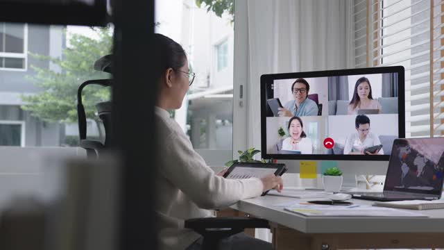 女商人在视频会议上谈论销售报告。亚洲团队使用笔记本电脑和平板电脑进行在线视频会议。在家工作，远程工作和在家自我隔离视频素材