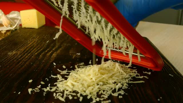 厨师将切达干酪磨碎，用于制作披萨、意大利面或其他菜肴。视频素材