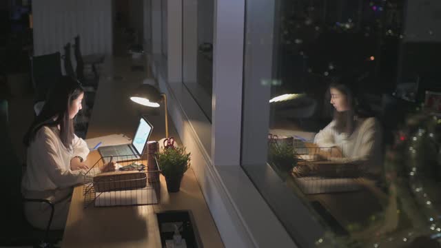 亚洲华裔女白领在办公室工作到深夜独自赶财务报告视频素材