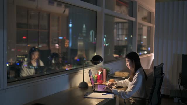 亚洲华裔女白领在办公室工作到深夜独自赶财务报告视频素材