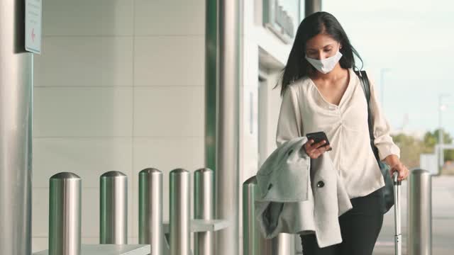 一名女子在离开机场时使用拼车应用视频下载