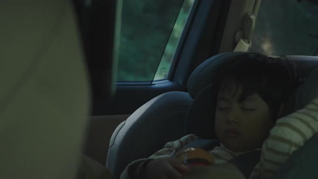 小男孩睡在车里的安全座椅上。视频下载
