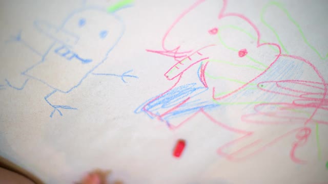 幼儿园小朋友在白纸上画动物脸的俯视图。视频下载