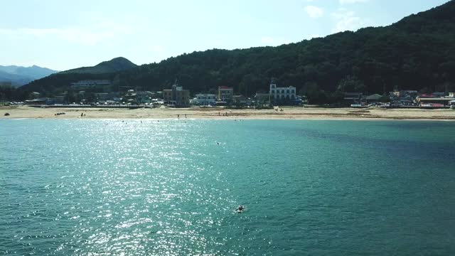 韩国江原道东海寺大津海滩上的人们在冲浪视频素材