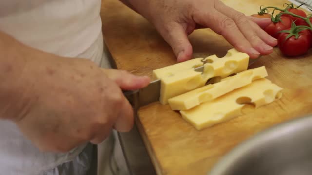 女厨师或家庭主妇切奶酪的特写视频素材