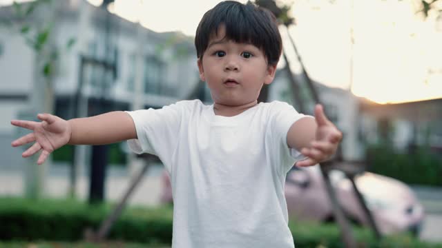 可爱的小男孩在乡村公园的绿草地上奔跑视频素材