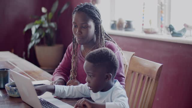 年轻的母亲在帮助儿子做功课视频下载