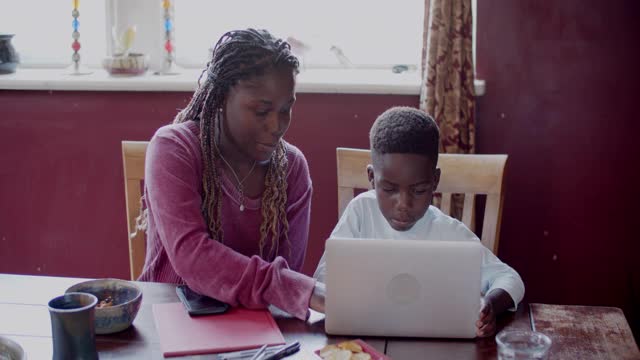 年轻的母亲在帮助儿子做功课视频素材