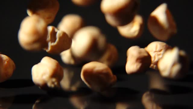 鹰嘴豆落在黑色背景微距拍摄的慢动作视频素材