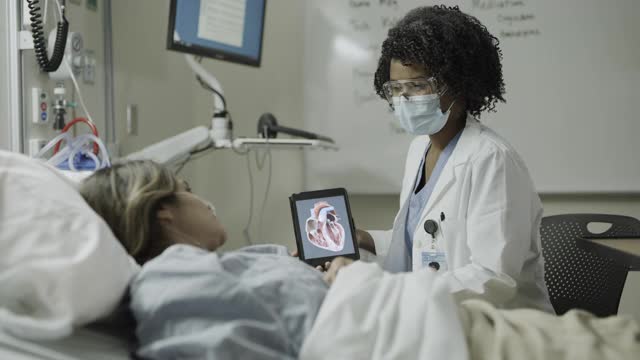 美国犹他州盐湖城，医生向病床上的病人展示心脏视频下载