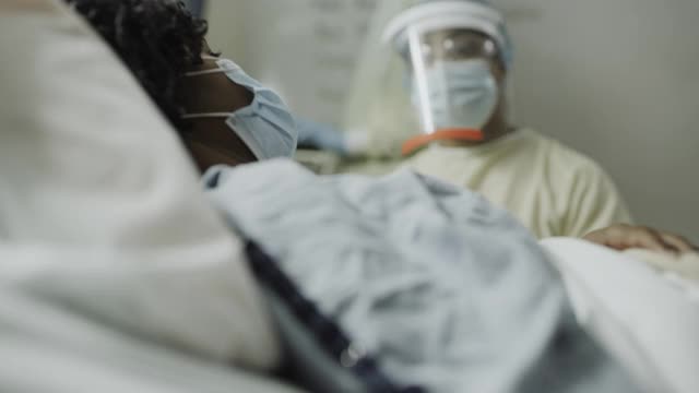 美国犹他州盐湖城，戴着防护设备的护士与感染病人交谈时，请抬起身体，拉近距离视频素材