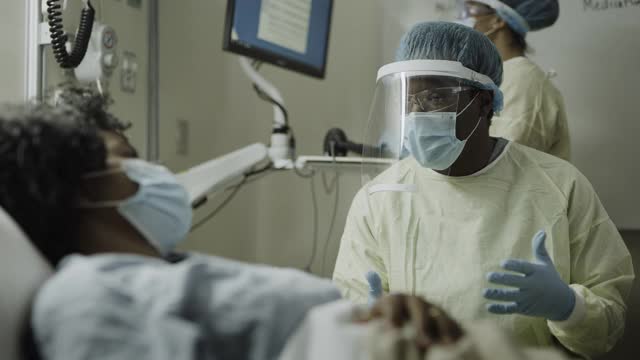 美国犹他州盐湖城，穿着防护装备的护士与感染病人交谈的特写视频素材