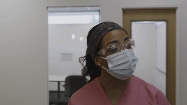 护士戴着外科口罩走在医院走廊的近距离跟踪镜头/盐湖城，犹他州，美国视频素材
