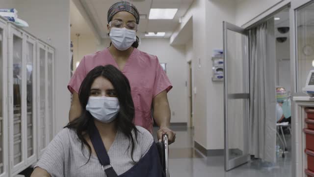 护士推医院的病人在轮椅然后医生加入和谈论的特写/盐湖城，犹他州，美国视频下载